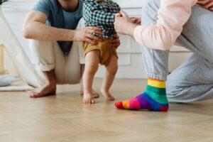 Genitori che aiutano un bimbo nei primi passi
