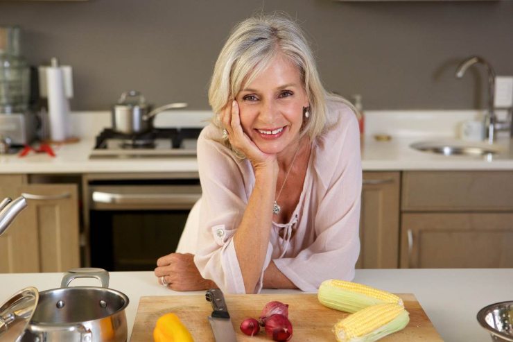 Donna over 50 che sorride in cucina