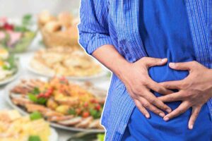 persona che si tiene l'addome con le mani e alimenti sfocata