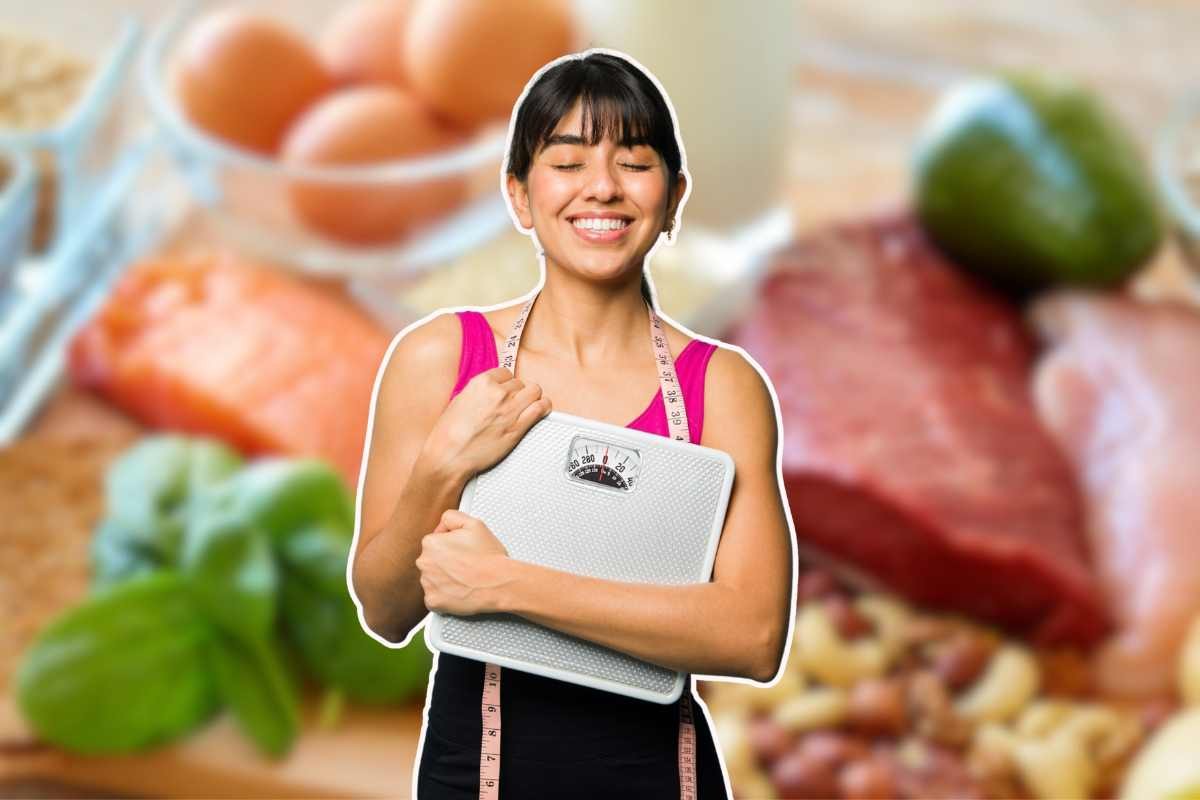 ragazza con la bilancia in mano in primo piano e alimenti sullo sfondo