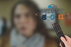logo mediaset, telecomando e immagine sfocata