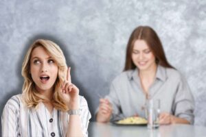 donna che mangia pasta e un'altra che pensa