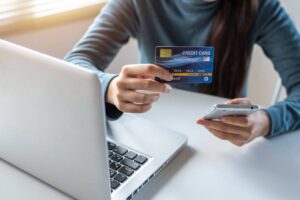 Donna che tiene in mano una carta di credito e un cellulare